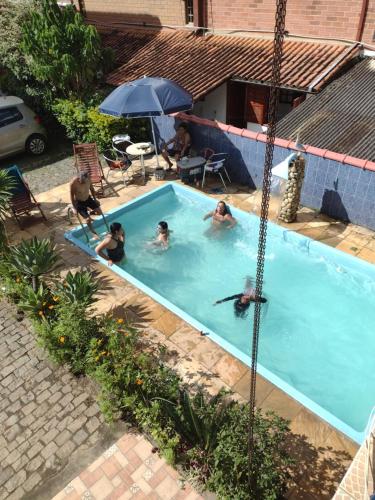 a group of people in a swimming pool at Pousada Oca Porã in Conservatória