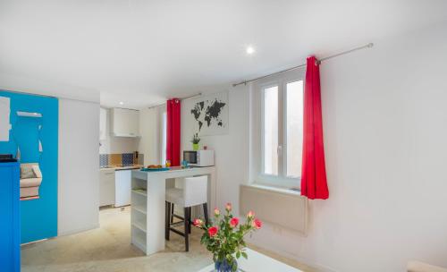 une cuisine avec des rideaux rouges, une table et une fenêtre dans l'établissement Le Saint Louis Blue Bulldog, à Hyères