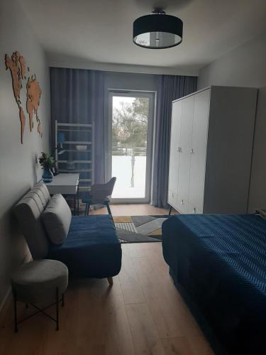 1 dormitorio con cama, silla y escritorio en Luksusowy Apartament Parkowa Olecko, en Olecko