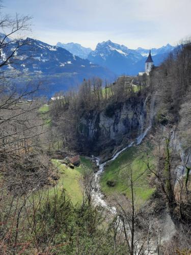 a church on the side of a mountain with a river at Large Apartment 8beds great for family and friends, Mountain View in Amden