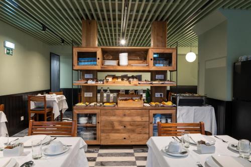 restauracja z dwoma stołami i ladą z jedzeniem w obiekcie Blue Liberdade Hotel w Lizbonie