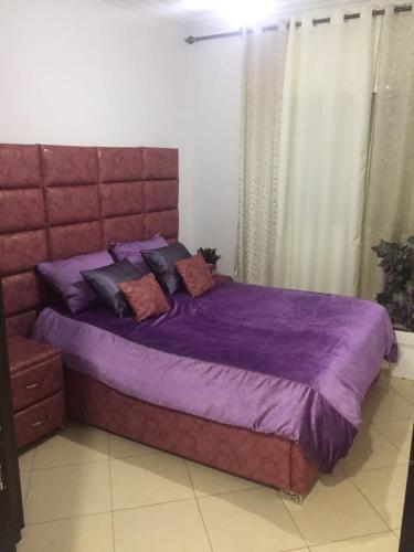 a bed with purple sheets and pillows in a bedroom at apparemment à louer pour les familles in Meknès