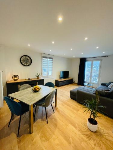 un salon avec une table et un canapé dans l'établissement Appartement Les Tilleuls 