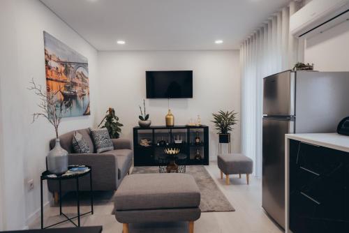 a living room with a couch and a refrigerator at Cabanelas Country House - Casa do Luís in Vale de Cambra
