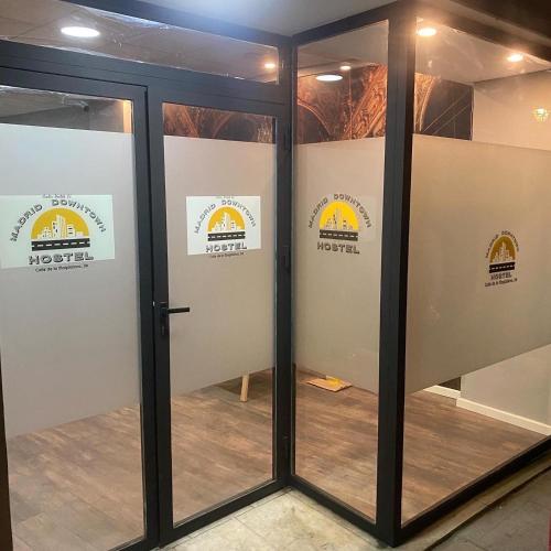 a pair of glass doors with signs on them at Madrid Downtown Hostel in Madrid