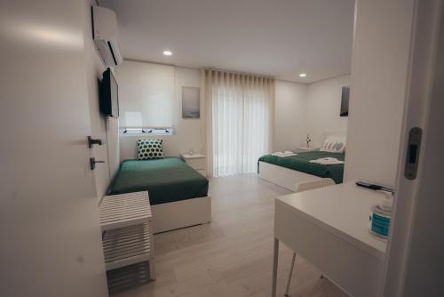 瓦萊迪坎布拉的住宿－Cabanelas Country House - Casa do Luís，酒店客房设有两张床和一张桌子。