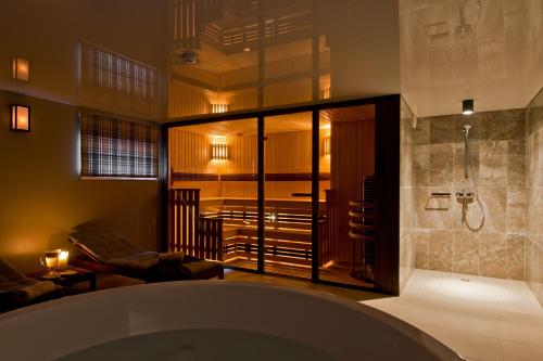 a bathroom with a shower and a bath tub at Palanga Visit Apartments and SPA in Palanga