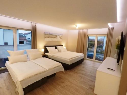 a hotel room with two beds and a balcony at -Neubau- 42 qm Balkon-Apartment in Fulda