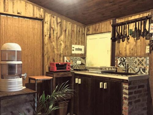 eine Küche mit Holzwänden und einer Theke mit einem Herd in der Unterkunft casa campeche in Subachoque