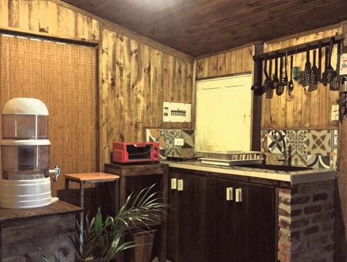 a kitchen with wooden walls and a counter with a stove at casa campeche in Subachoque