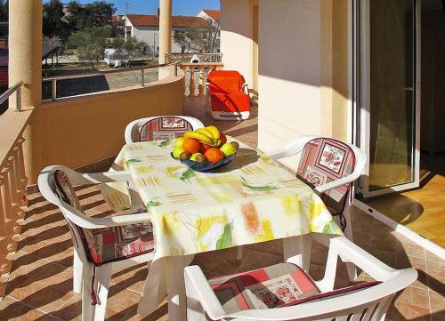 einen Tisch mit einer Obstschale auf dem Balkon in der Unterkunft Nives apartmani in Pakoštane