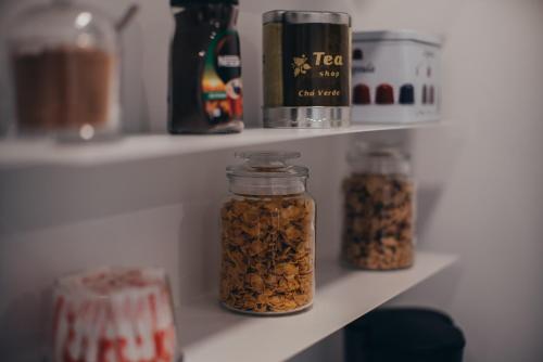 three jars of nuts on a shelf in a refrigerator at Cabanelas Country House - Casa do Luís in Vale de Cambra