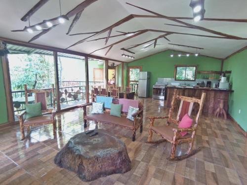a room with chairs and a table with a tree stump at Canopy Wonders Vacation Home in Monteverde Costa Rica
