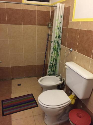 a bathroom with a toilet and a shower curtain at ALOJAMIENTO SERRANO in Villa Giardino