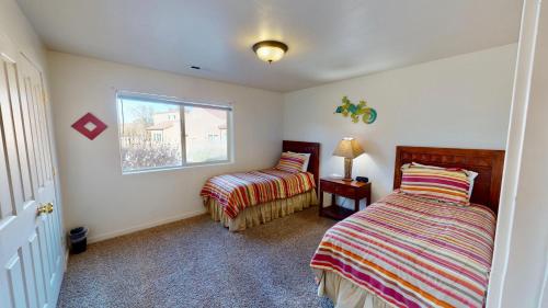 a bedroom with two beds and a window at Desert Hideaway #C2 in Moab