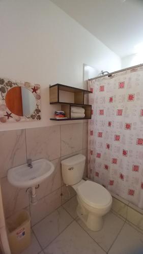 a bathroom with a toilet and a sink at Hospedaje Ola Marina in Máncora