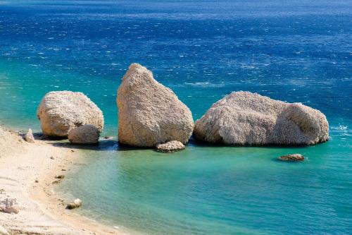 three large rocks in the water on a beach at Durdica beautiful garden with fantastic sea and mountain views in Metajna