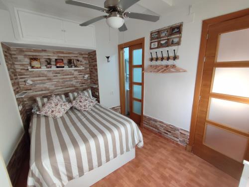 sypialnia z łóżkiem i wentylatorem sufitowym w obiekcie Reina Mercedes w mieście Chipiona
