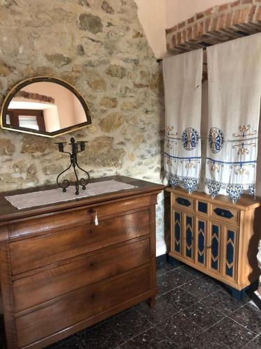 a bathroom with a wooden dresser and a mirror at LOCAZIONE TURISTICA IL BRICCHETTO in Parodi Ligure