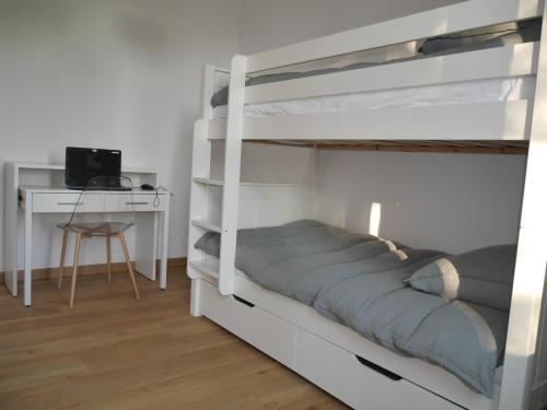 1 Schlafzimmer mit 2 Etagenbetten und einem Schreibtisch in der Unterkunft Spacieux F5 au parc arboré in Orsay