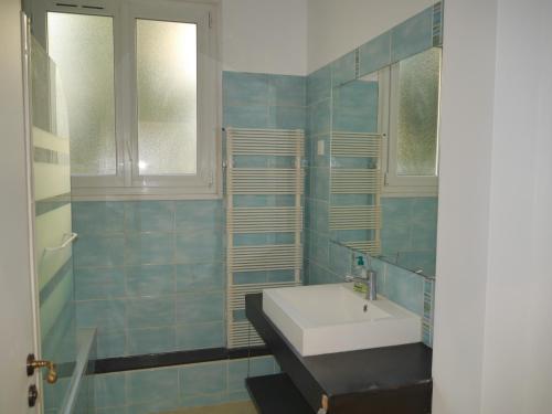 ein Bad mit einem Waschbecken und einem Spiegel in der Unterkunft Spacieux F5 au parc arboré in Orsay