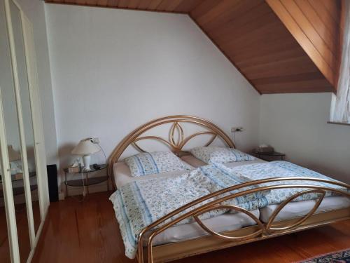 a bed in a bedroom with a wooden ceiling at Wohnen beim Uswatta Liyanage in Troisdorf
