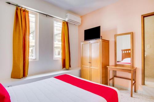 a bedroom with a bed and a dresser and a mirror at Hotel La Estancia in Colima