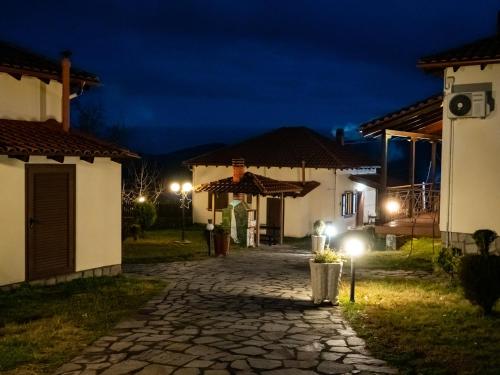 a cobblestone path between two buildings at night at Karyon Apartments in Kariófiton
