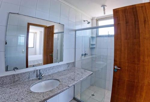 un bagno con lavandino e specchio di Cobertura c/ vista para o mar e montanhas, churrasqueira, 4 quartos 2 Vg garagem a Guarapari