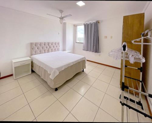 una camera ospedaliera con un letto e una finestra di Cobertura c/ vista para o mar e montanhas, churrasqueira, 4 quartos 2 Vg garagem a Guarapari