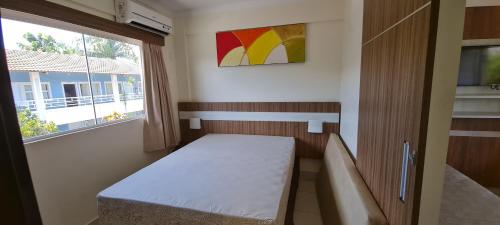 a small room with a bed and a window at Lacqua diRoma 1 - Apartamentos JN in Caldas Novas