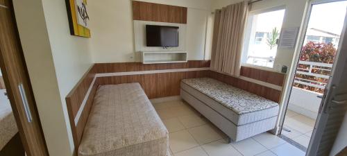 a room with a couch and a tv and a window at Lacqua diRoma 1 - Apartamentos JN in Caldas Novas