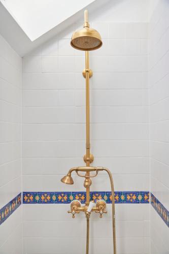 a shower with a brass light in a bathroom at Casa do Mercado Lisboa in Lisbon