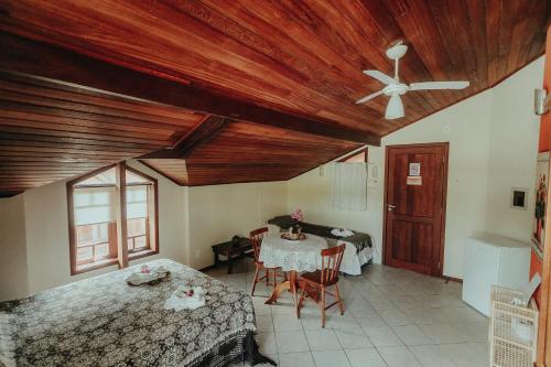 a bedroom with a table and a ceiling fan at Pousada Colinas da Lagoa in Florianópolis