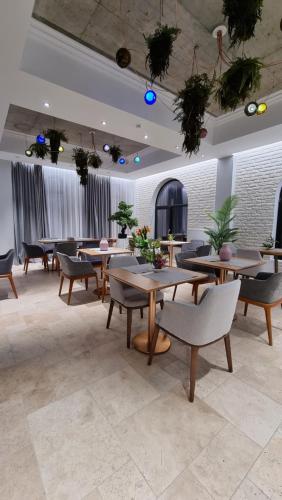 フォクシャニにあるARN Boutique Hotelのテーブルと椅子が備わるレストラン