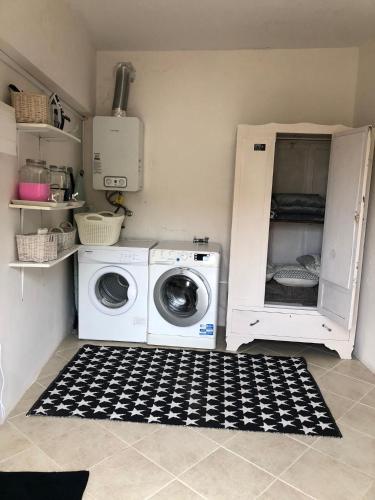 a laundry room with a washing machine and a cabinet at Casa da Grota in Porto Moniz