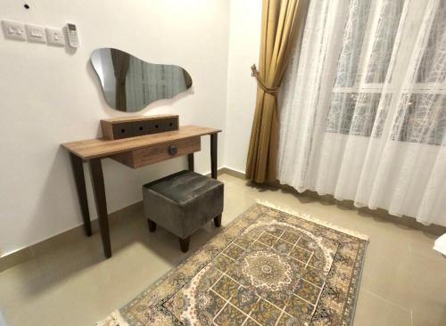 a dressing room with a desk and a mirror and a stool at Alhamra Horizons in Al Ḩamrāʼ
