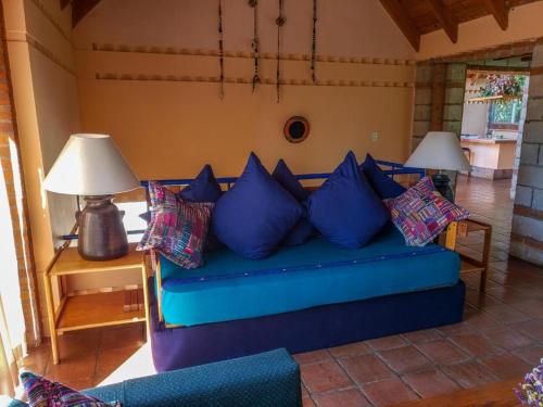 a blue couch with pillows in a living room at Hotel San Buenaventura de Atitlán in Panajachel
