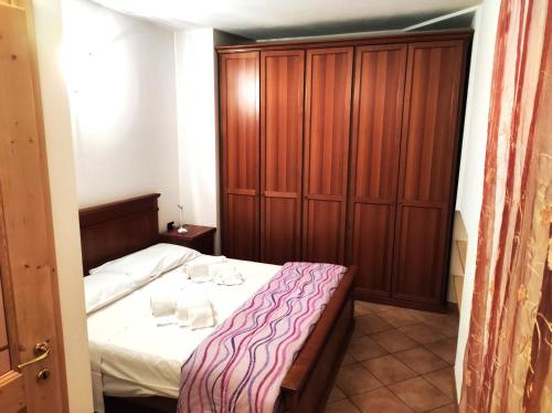 1 dormitorio con 1 cama y armario de madera en Apartment "Casa Maya" en Mezzana