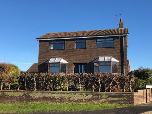 a brick house with a hedge in front of it at Number One - Fully Equipped Self Catering Four Bedroom House next to Dunedin, 15 mins to Spurn, 20 mins to Saltend, 12 mins to Easington in Patrington