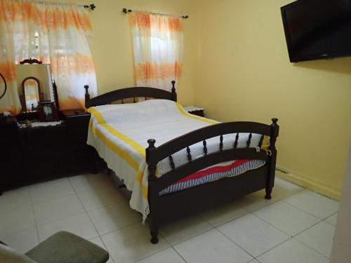 a bedroom with a bed with a yellow and white blanket at Urban Oasis Apartment in Castries