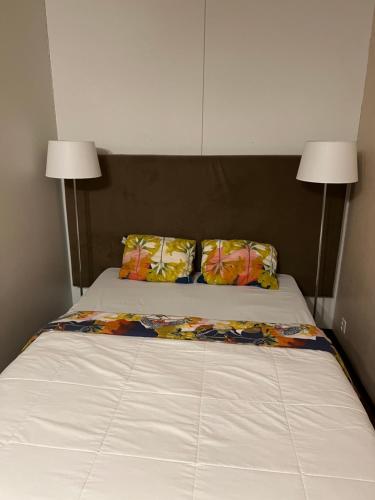 1 cama con 2 almohadas y 2 lámparas. en Myllykoski apart, en Ummeljoki