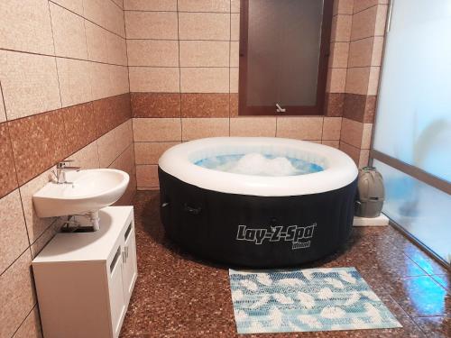 a bathroom with a black and white tub and a sink at Mátra Wellness Vendégház in Parádsasvár