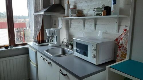 a kitchen counter with a microwave and a sink at Båstad Stationsterrassen 7 in Båstad