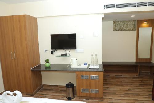a room with a desk with a tv on the wall at Gadiraju Palace Convention Centre & Hotel in Visakhapatnam