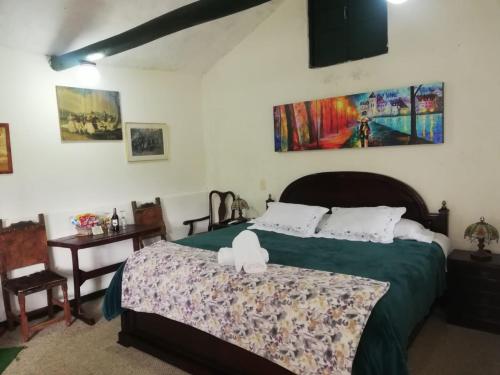 a bedroom with a bed with a green comforter at Hotel y Centro de Convenciones Pueblito de Yerbabuena Paraíso Natural in Chía