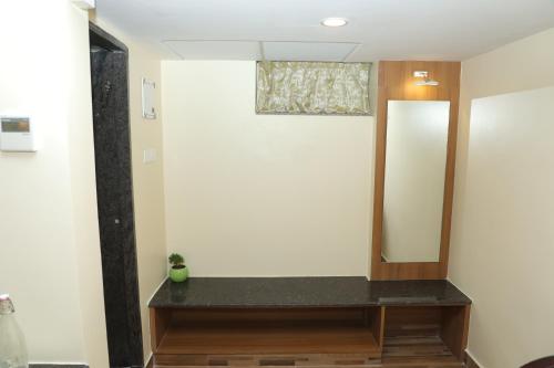 a bathroom with a mirror on a wall at Gadiraju Palace Convention Centre & Hotel in Visakhapatnam