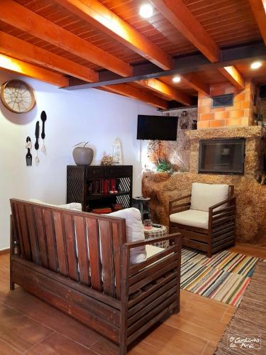 a living room with a couch and a tv at O Cantinho da Ana in Sortelha