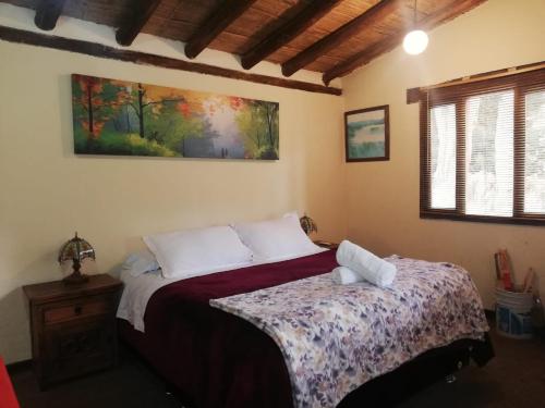 a bedroom with a bed and a painting on the wall at Hotel y Centro de Convenciones Pueblito de Yerbabuena Paraíso Natural in Chía