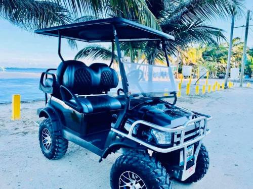 a black golf cart parked on the beach at Hotel Coastalbay 2 & Golf Cart Rental in San Pedro